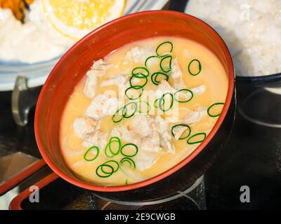 Primo piano di una zuppa con pollo e spezie una ciotola marrone Foto Stock