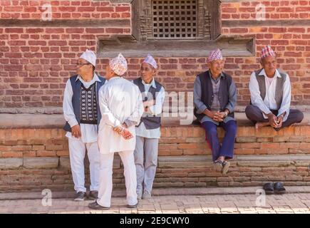 Uomini anziani seduti a parlare in piazza Durbar a Patan, Nepal Foto Stock