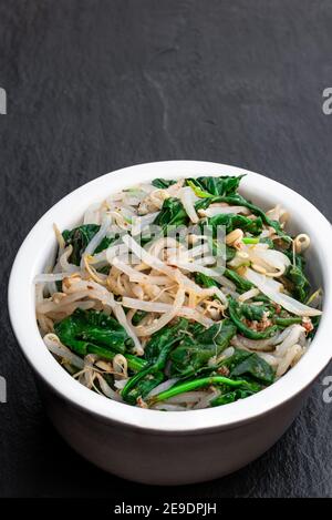 Insalata di germogli di fagioli di spinaci coreani su fondo di pietra Foto Stock