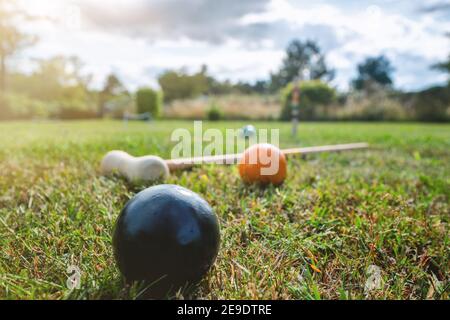 Croquet gioco all'aperto su un prato in estate con un mallet e palline colorate Foto Stock