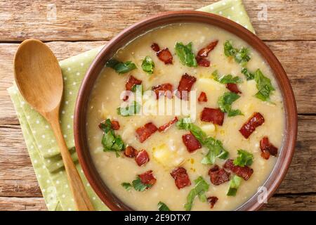 Zuppa bavarese di rumford e orzo con pancetta primo piano in un piatto sul tavolo. Vista dall'alto orizzontale Foto Stock