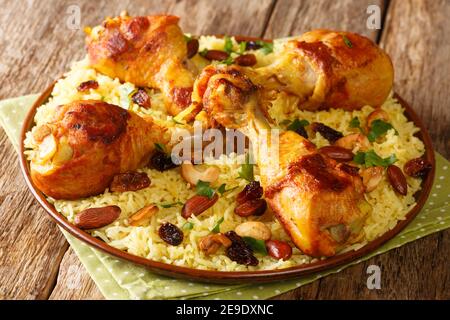 Il Majboos è un tradizionale piatto di riso arabo che incorpora il guardaroba di carne di pollo nel piatto sul tavolo. Orizzontale Foto Stock