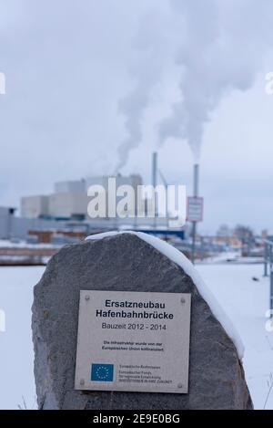 30 gennaio 2021, Sassonia-Anhalt, Magdeburgo: 'Nuovo ponte portuale di sostituzione' è scritto su una pietra di granito nel porto industriale di Rothensee. Dietro di essa si possono vedere i camini fumanti della centrale di Magdeburgo. Foto: Stephan Schulz/dpa-Zentralbild/ZB Foto Stock