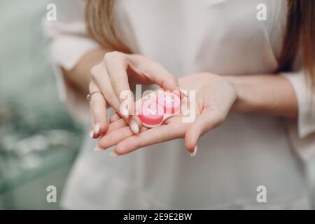 Contenitore a scatola per lenti a contatto donna custodia per le mani per lenti. Foto Stock