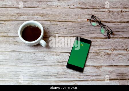 Un telefono cellulare o un telefono cellulare posto su un tavolo O scrivania con l'app Bet 365 aperta e una caffè accanto ad esso Foto Stock