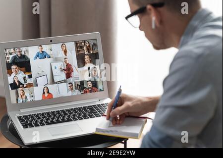 Brainstorming, video meeting online, conferenza virtuale con colleghi multietnici, dipendenti e colleghi. Vista sulla spalla di un ragazzo su uno schermo con Foto Stock