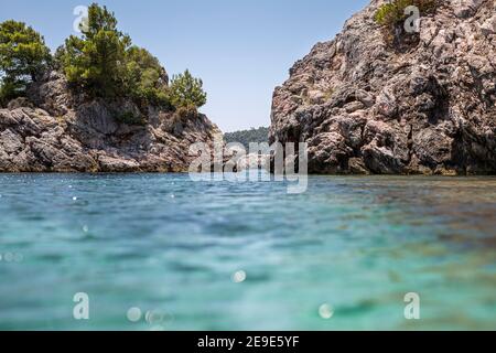 Big Rock nelle acque blu di Stafilos Beach, Skopelos, Skopelos Island, Grecia in una calda giornata estiva. Foto Stock