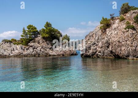 Big Rock nelle acque blu di Stafilos Beach, Skopelos, Skopelos Island, Grecia in una calda giornata estiva. Foto Stock