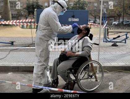 Malaga, Spagna. 04Feb 2021. Un operatore sanitario che indossa una tuta per dispositivi di protezione individuale (PPE) raccoglie campioni di swap da una donna al di fuori di una cancelleria di prova del coronavirus durante un test di covid-19 massiccio a Plaza Limeno piazza nel centro della città. A causa dell'elevato tasso di infezioni da coronavirus nella capitale di Malaga, circa 1.600 volontari sono stati selezionati dalle autorità sanitarie per partecipare a un test casuale per la covid-19 dell'antigene. Credit: SOPA Images Limited/Alamy Live News Foto Stock