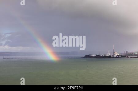 WhiteGate, Cork, 04 febbraio 2021. Un arcobaleno si rompe attraverso le nuvole vicino ai serbatoi di stoccaggio presso la raffineria di petrolio a WhiteGate, Co. Cork, Irlanda. - credito; David Creedon / Alamy Live News Foto Stock