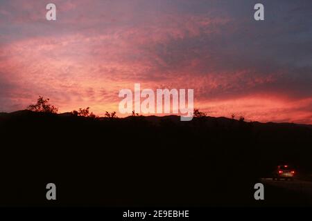 Auto che guida in fuoristrada nel tramonto intenso in colombia Foto Stock