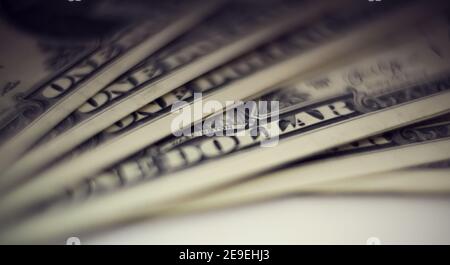 Sfondo sfocato con le fatture di un dollaro. Un'ira di dollari. Foto Stock