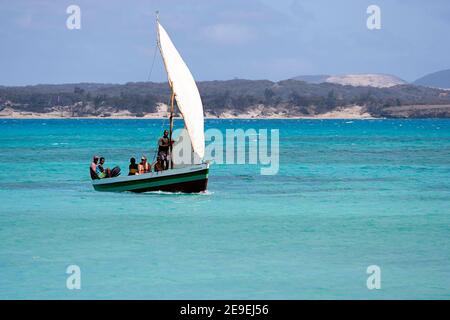 I turisti a bordo di un tradizionale peschereccio in legno navigano in acque turchesi di una splendida baia di smeraldo (Mer d'Emeraude), Antsiranana, Madagascar Foto Stock