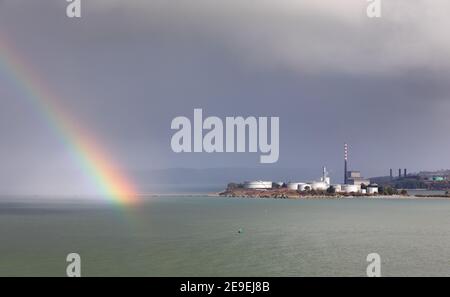 WhiteGate, Cork, 04 febbraio 2021. Un arcobaleno si rompe attraverso le nuvole vicino ai serbatoi di stoccaggio presso la raffineria di petrolio a WhiteGate, Co. Cork, Irlanda. - credito; David Creedon / Alamy Live News Foto Stock