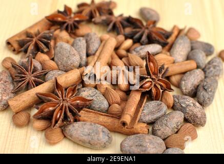 Vista dall'alto degli ingredienti per cioccolato, cacao in grani, cannella, anice, albicocche su fondo naturale di legno, fuoco selettivo Foto Stock