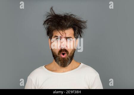 Divertente e pazzo. Uomo bearded con i capelli disordinati. Concetto di barbiere. Barba lunga e baffi. Foto Stock