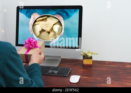 Scambio virtuale di regali. L'uomo e la donna che offrono i regali in linea. San Valentino virtuale. Foto Stock