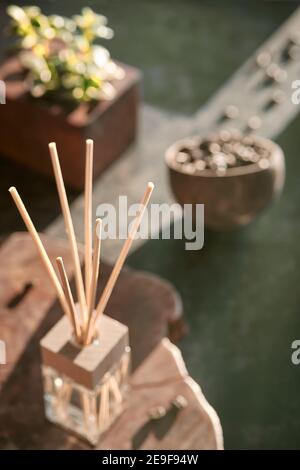 Deodorante per ambienti con bastoncini di bambù con profumo in vetro su sfondo scuro testurizzato. Rinvigorente odore di caffè. Sfondo scuro. Caffè arrosto in grani Foto Stock