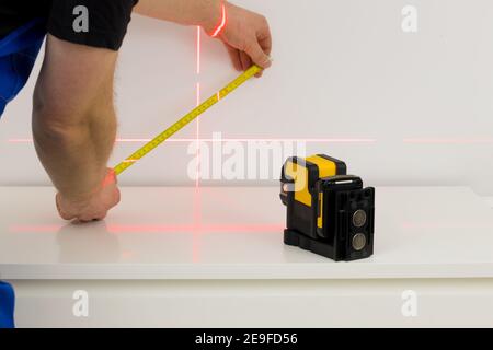 linee sulla parete contrassegnate da un laser elettronico utilizzato per determinare gli angoli durante le misure di costruzione e le lavorazioni di finitura interna Foto Stock