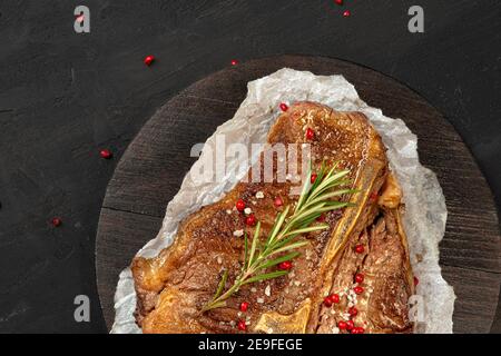 Vista dall'alto della bistecca di ossa grigliata sul tavolo nero Foto Stock