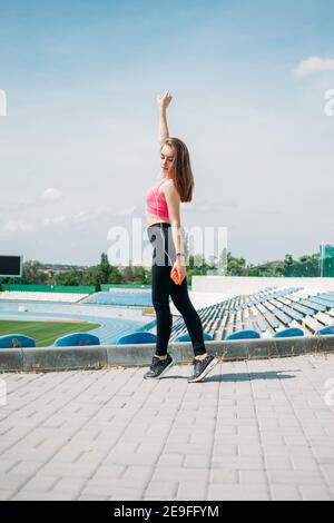 Teen Fitness, attività fisica per gli adolescenti. Giovane ragazza sportiva con allenamento, corsa, facendo esercizi allo stadio Foto Stock