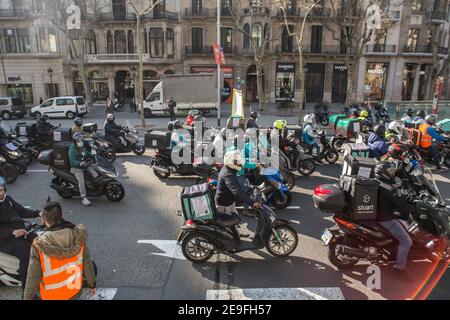 Gli addetti alla consegna si fermano per strada durante la dimostrazione.centinaia di persone provenienti da diverse piattaforme di consegna a domicilio, come Deliveroo, Uber Eats, Glovo, Stuart e anche da Amazon o Seur hanno fatto un tour a Barcellona per onorare le loro auto, Moto e biciclette in varie città in tutta la Spagna durante una protesta contro l'approvazione della nuova legge Rider che mira a regolare la situazione di questi lavoratori e far scomparire la figura dei falsi lavoratori autonomi. La nuova legislazione costringerà le imprese ad assumere i loro lavoratori, e cesseranno di essere lavoratori autonomi per essere s. Foto Stock