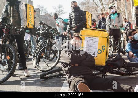 Durante la dimostrazione, un protetore si siede sul pavimento con una bicicletta e una borsa Glovo.centinaia di persone provenienti da diverse piattaforme di consegna a domicilio, come Deliveroo, Uber Eats, Glovo, Stuart e anche da Amazon o Seur, hanno fatto un tour a Barcellona per onorare le loro auto, Moto e biciclette in varie città in tutta la Spagna durante una protesta contro l'approvazione della nuova legge Rider che mira a regolare la situazione di questi lavoratori e far scomparire la figura dei falsi lavoratori autonomi. La nuova legislazione costringerà le aziende a assumere i propri lavoratori, e cesseranno di essere autoemplo Foto Stock