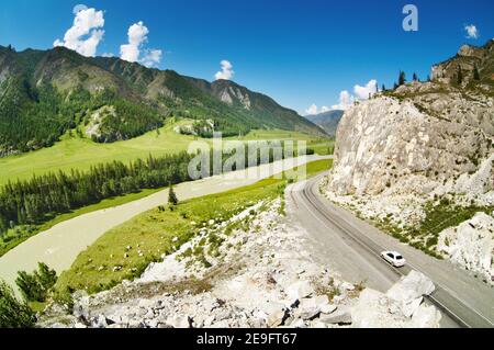 Paesaggio montano con strada e fiume Foto Stock