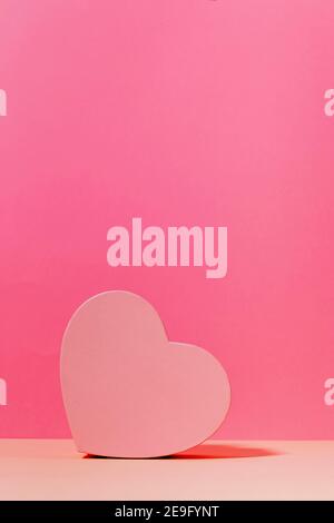 Scatola a forma di cuore per regali il giorno di San Valentino in rosa chiaro con fondo rosa Foto Stock