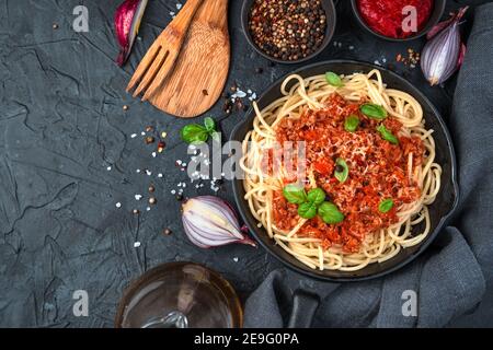 Deliziosa pasta con salsa di pomodoro, rosmarino e spezie su fondo nero di cemento. Foto Stock