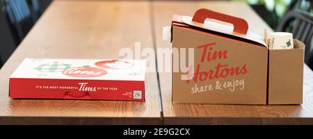 3 Febbraio 2021 - Calgary , alberta Canada - Tim Hortons ciambella e caffè sul tavolo da ufficio Foto Stock