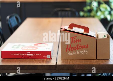 3 Febbraio 2021 - Calgary , alberta Canada - Tim Hortons ciambella e caffè sul tavolo da ufficio Foto Stock