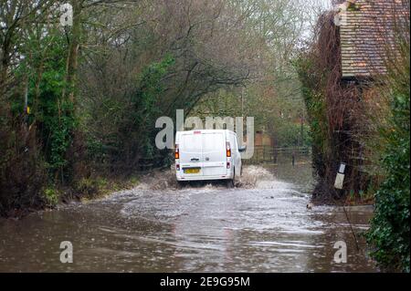 Sonning, Berkshire, Regno Unito. 4 febbraio 2021. Un pulmino bianco attraversa le acque alluvionali su una strada chiusa a Sonning. Dopo la pioggia pesante negli ultimi giorni, il Tamigi ha fatto esplodere le sue sponde a Sonning, nel Berkshire. È stato attivato un allarme alluvione e le strade, i sentieri e i campi bassi si sono allagati. Anche se la B478 attraverso il ponte di Sonning è chiusa a causa delle inondazioni, alcuni conducenti ignoravano i cartelli di chiusura della strada e guidavano attraverso le inondazioni. Credito: Maureen McLean/Alamy Foto Stock