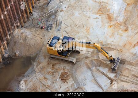 digger in buca di costruzione con palafitte Foto Stock