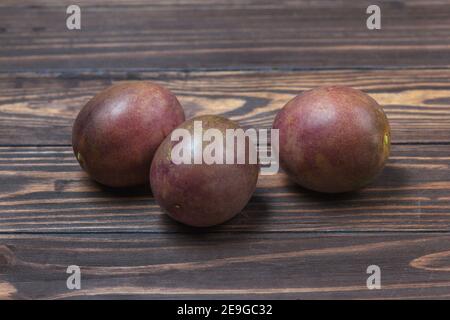 Frutto di passionfruit maturo, adagiato su uno sfondo di tavole di legno. Foto di alta qualità Foto Stock