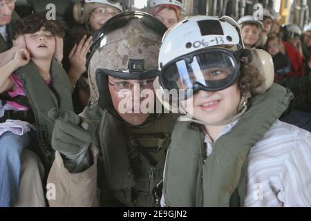 'Una marina degli Stati Uniti aiuta un bambino piccolo a raggiungere una finestra dall'interno di un US Marine Corps CH-53E Super Stallion elicottero, assegnato ai ''Cavalieri Blu'' di Marine Medium Helicopter Squadron tre sei cinque, durante il loro volo a Akrotiri, Cyrus il 18 luglio 2006. Su richiesta dell'Ambasciatore degli Stati Uniti in Libano e sotto la direzione del Segretario della Difesa, il comando centrale degli Stati Uniti e la 24a unità di spedizione marittima (24 MEU) stanno assistendo alla partenza dei cittadini statunitensi dal Libano. Foto USN bia ABACAPRESS.COM' Foto Stock