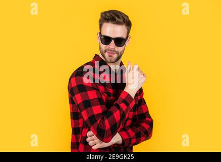 capelli ben curati, bellezza maschile e look fashion. camicia a scacchi per il ragazzo bearded. uomo bello sraduto con setole in occhiali da sole. concetto di parrucchiere. giovane e sicuro. il suo stile perfetto. Foto Stock