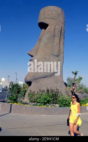 Una donna si laga davanti a una grande figura di Tiki fuori del Tropicana Hotel and Casino a Las Vegas, Nevada, Foto Stock