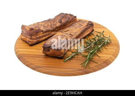 Deliziosa pancetta a lastre interamente affumicata artigianale su un blocco di taglio. Foto Stock