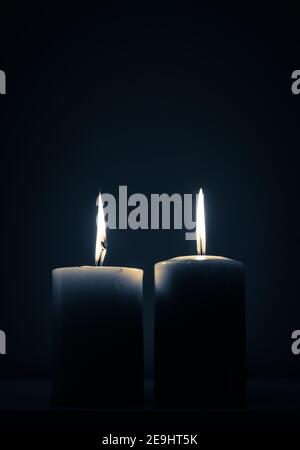 due candele che bruciano al buio Foto Stock