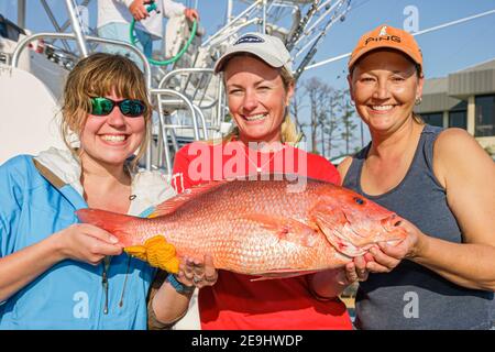 Alabama Orange Beach Zeke's Landing Red Snapper Tournament, donna donna donna che tiene pescato pesce cattura amici, Foto Stock
