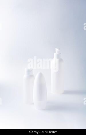 Bottiglie bianche mockup per marcare a caldo. Set di prodotti cosmetici per crema, zuppa, deodorante, shampoo su sfondo chiaro. Provette, dispenser e vasetti Foto Stock