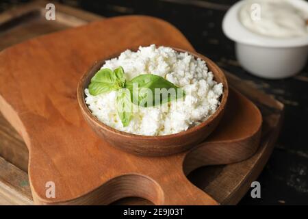 Ciotola con ricotta su sfondo di legno Foto Stock