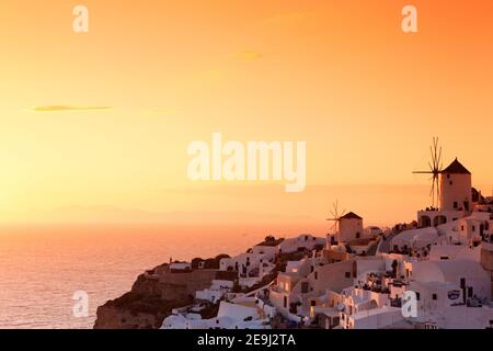 Santorini, Grecia il tramonto nella scogliera di Oia con le sue tradizionali case in stucco imbiancato. Foto Stock