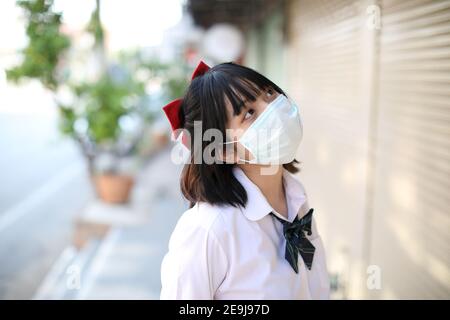 Ritratto scuola ragazza con maschera Foto Stock