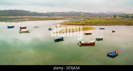 Barca da pesca nell'estuario di San Vicente de la Barquera. Tra Asturie e Cantabria. Spagna. Fotografia panoramica sulla costa Foto Stock