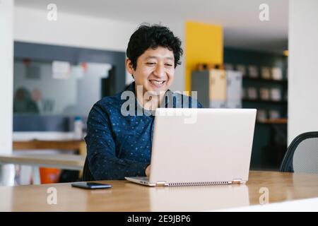 Giovane uomo d'affari latino che lavora alla sua scrivania in ufficio Città del Messico Foto Stock