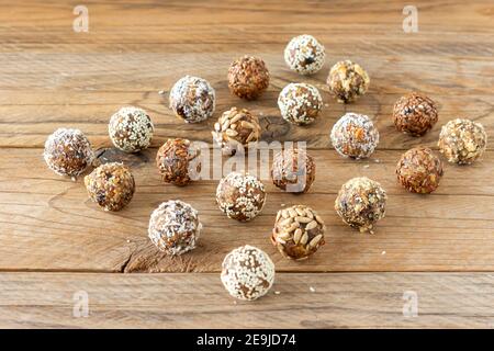 Palle di proteine di energia con ingredienti sani su tavola di legno. Casa fatta con datteri, mandorla, lino e semi Foto Stock