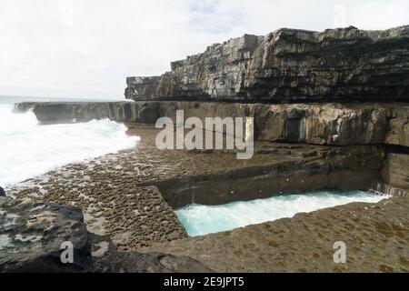 Scogliere e il famoso Worm Hole, una piscina naturale a Inishmore, isole Aran, Irlanda Foto Stock