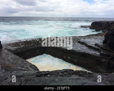 Scogliere e il famoso Worm Hole, una piscina naturale a Inishmore, isole Aran, Irlanda Foto Stock